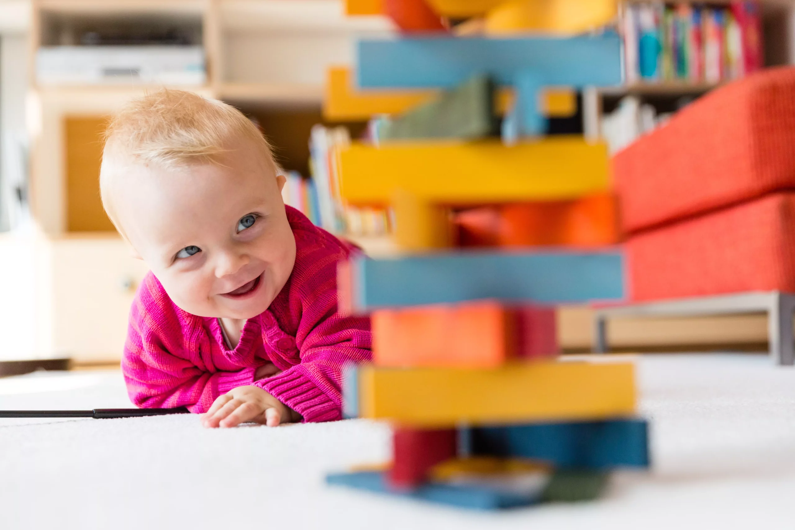 Symbolfoto von 5min.at: Baby spielt am Boden und entdeckt Bausteine.