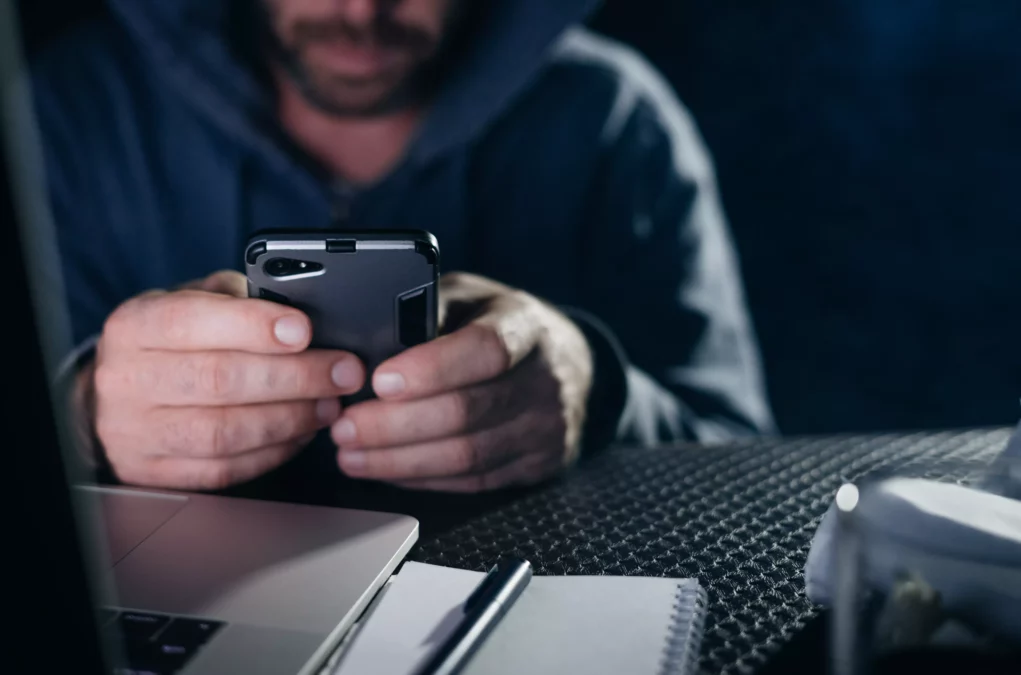 Symbolfoto von 5min.at: Krimineller hackt ein Passwort auf einem Telefon.