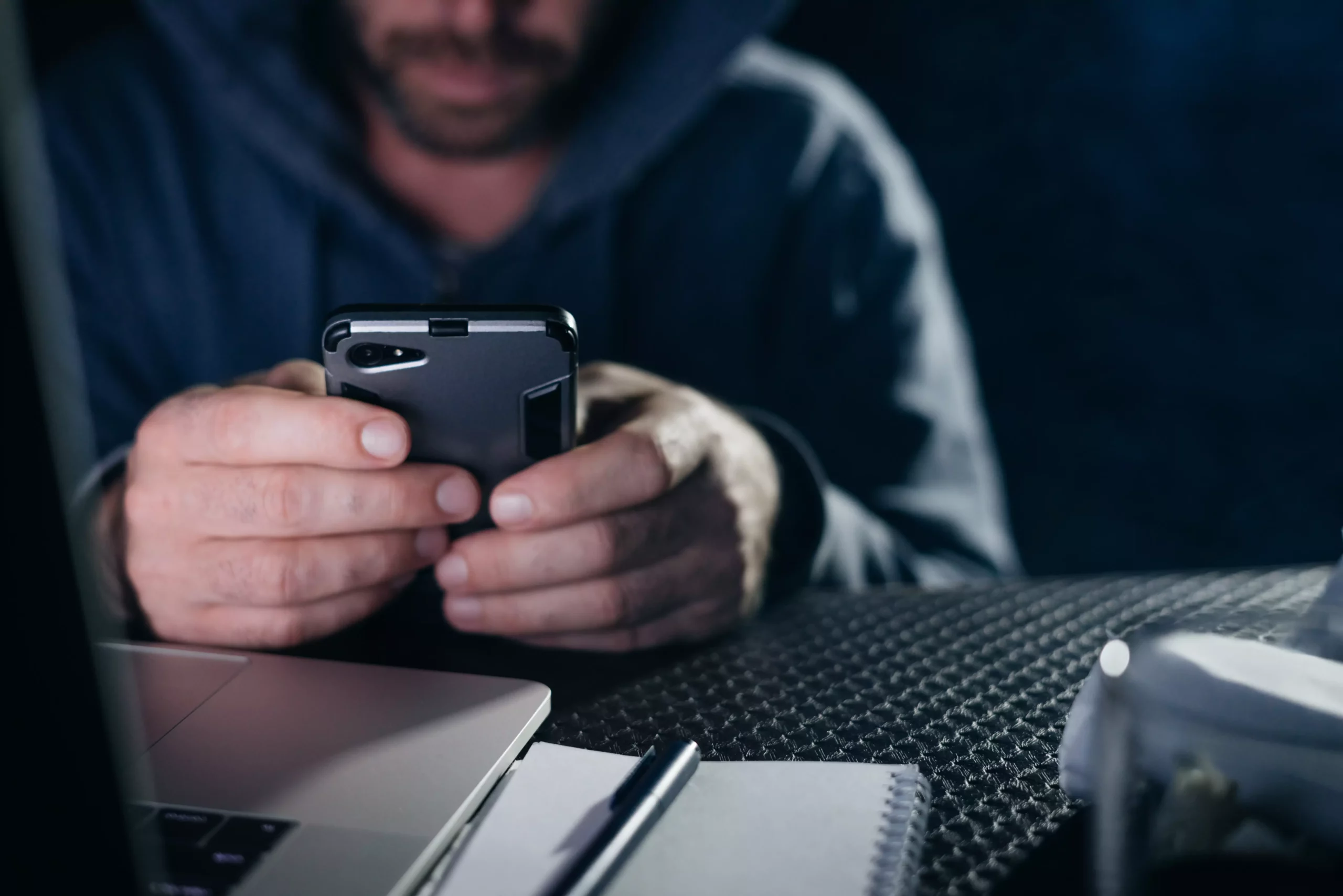 Symbolfoto von 5min.at: Krimineller hackt ein Passwort auf einem Telefon.