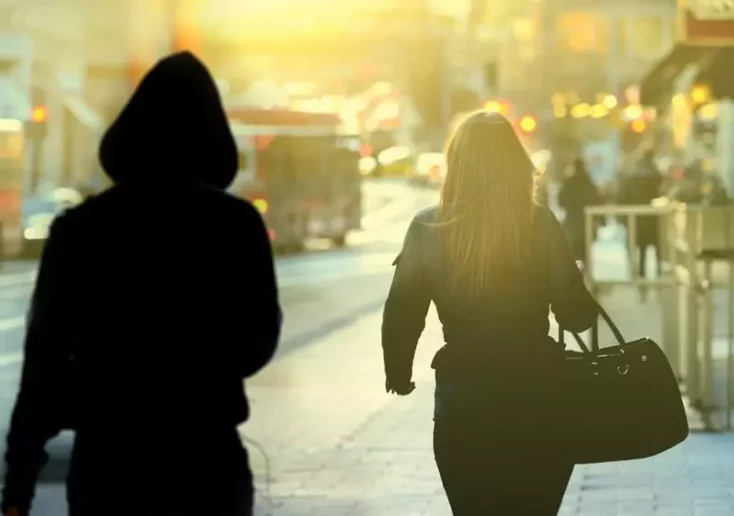 Symbolfoto zu einem Beitrag von 5min.at: Ein Dieb nähert sich von hinten einer Frau.