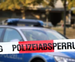 Symbolfoto zu einem Beitrag von 5min.at: Polizeiauto parkt hinter einem Absperrband.