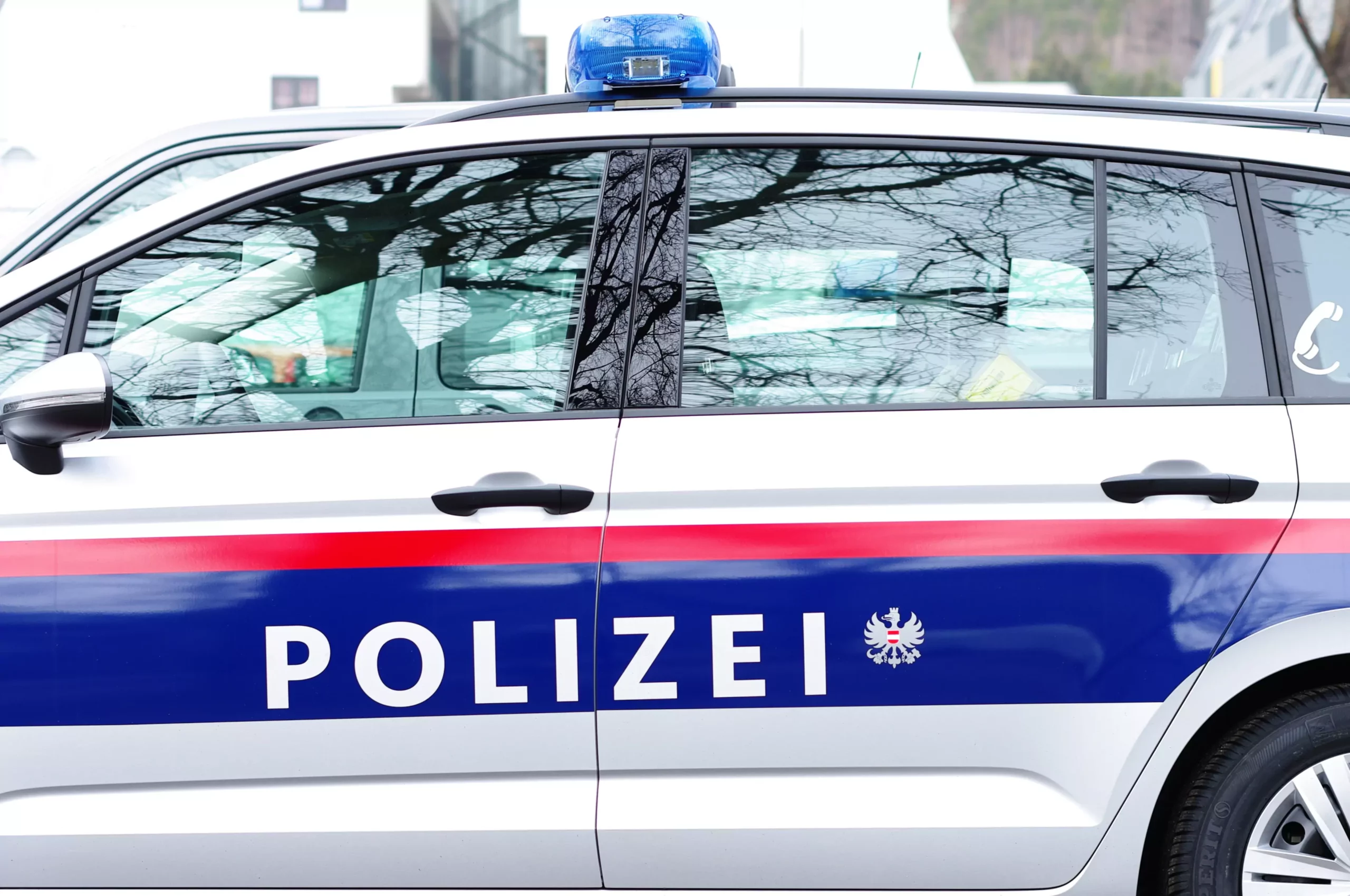 Symbolfoto zu einem Beitrag von 5min.at: Die Polizei parkt am Tag zu einem Einsatz.