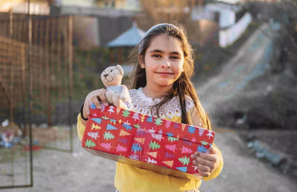 Symbolfoto zu einem Beitrag von 5min.at: Ein Mädchen hält ein Geschenk in der Hand