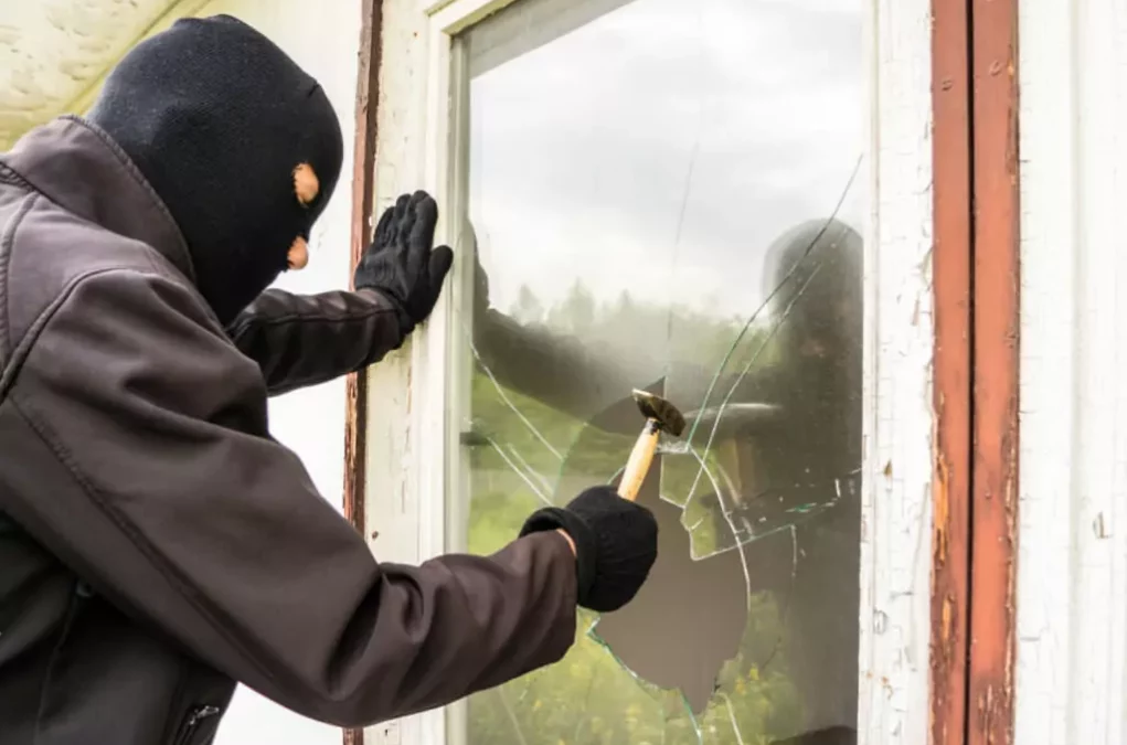 Symbolfoto von 5min.at: Einbrecher schlägt ein Fenster ein.