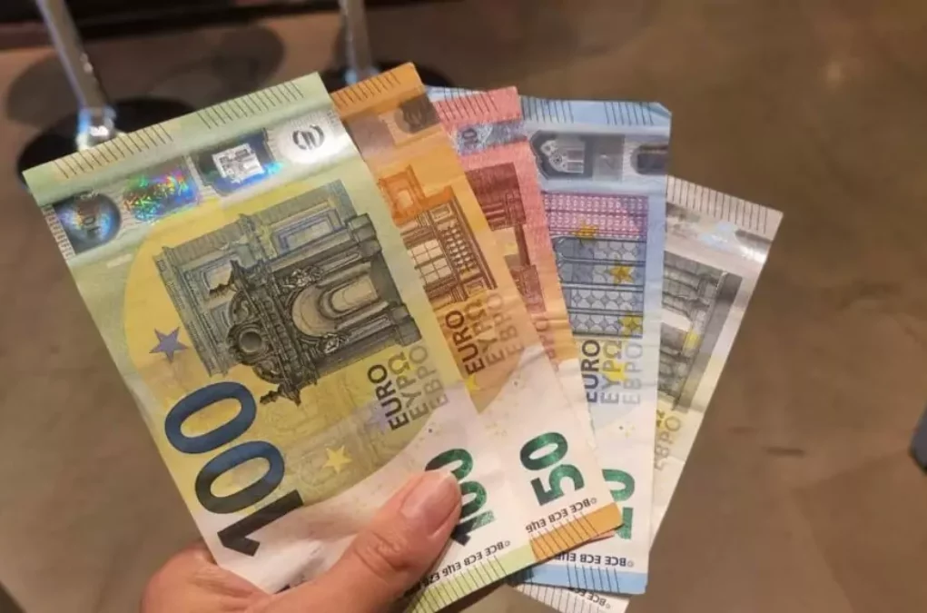 Symbolfoto von 5min.at: Frau hält verschiedene Geldscheine in der Hand.