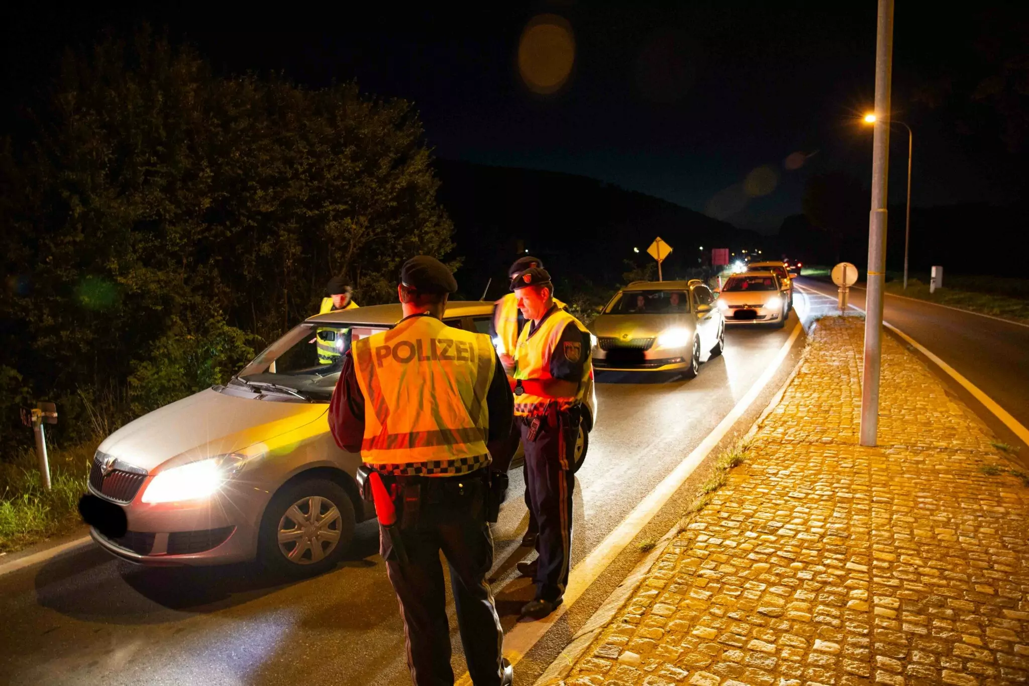 Symbolfoto zu einem Beitrag von 5min.at: Polizisten kontrollieren Autos bei Nacht