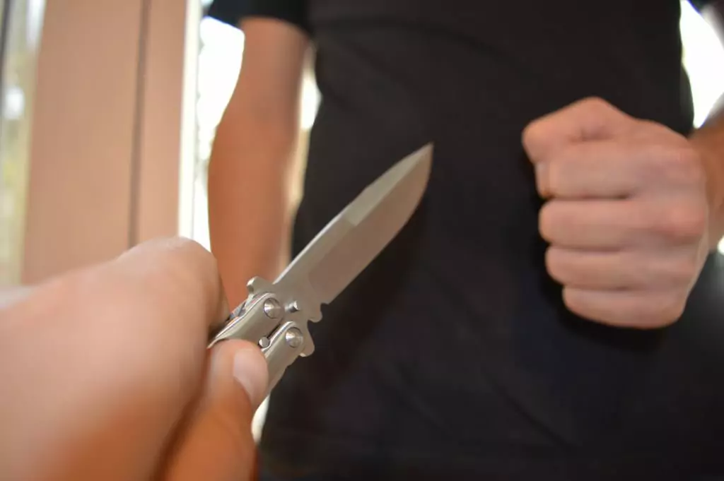 Symbolfoto von 5min.at: Mann droht sein Opfer mit einer Faust. Opfer verteidigt sich mit einem Messer.