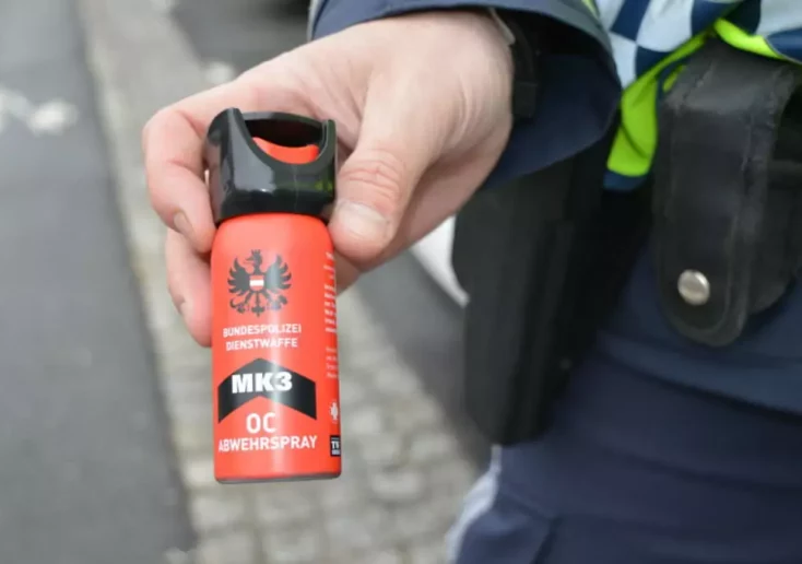 Symbolfoto von 5min.at: Polizist hält Pfefferspray in der Hand.