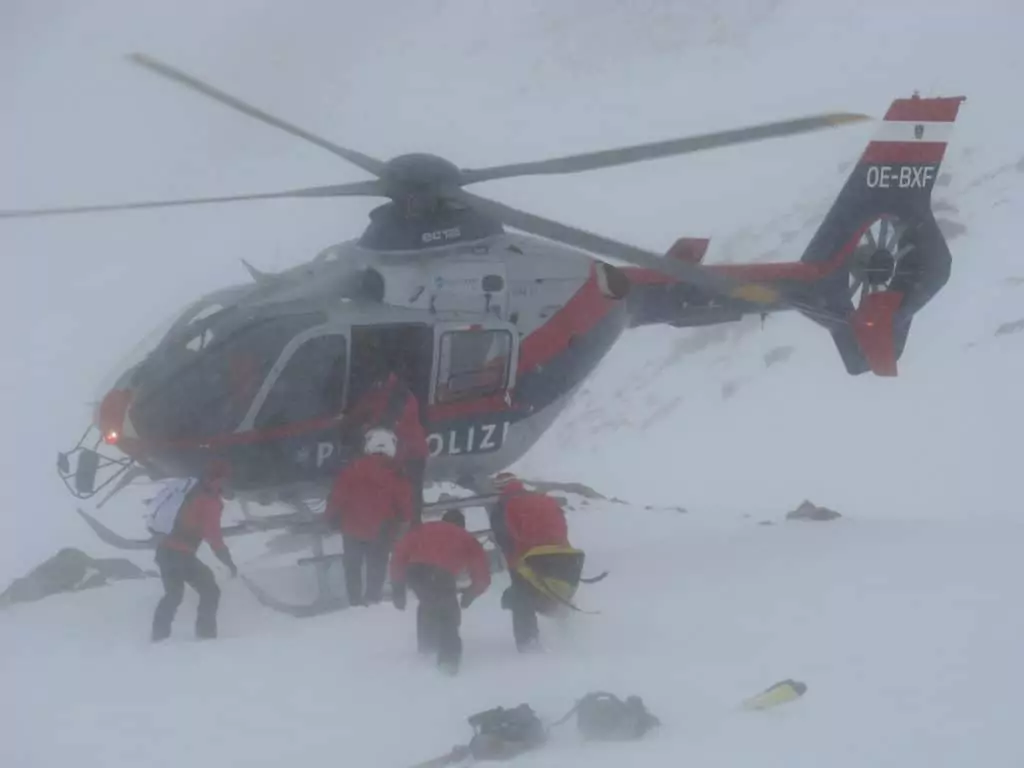 Symbolfoto von 5min.at: Polizeihubschrauber mit Rettern im Alpingelände im Winter.