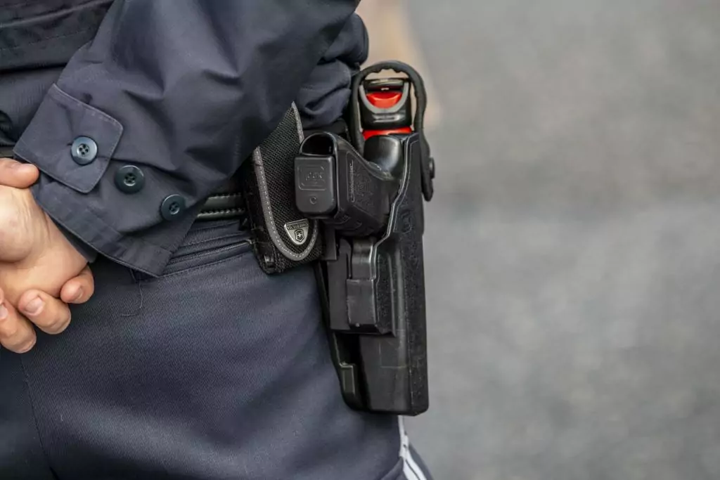 Symbolfoto von 5min.at: Nahaufnahme eines bewaffneten Polizisten mit Pfefferspray.