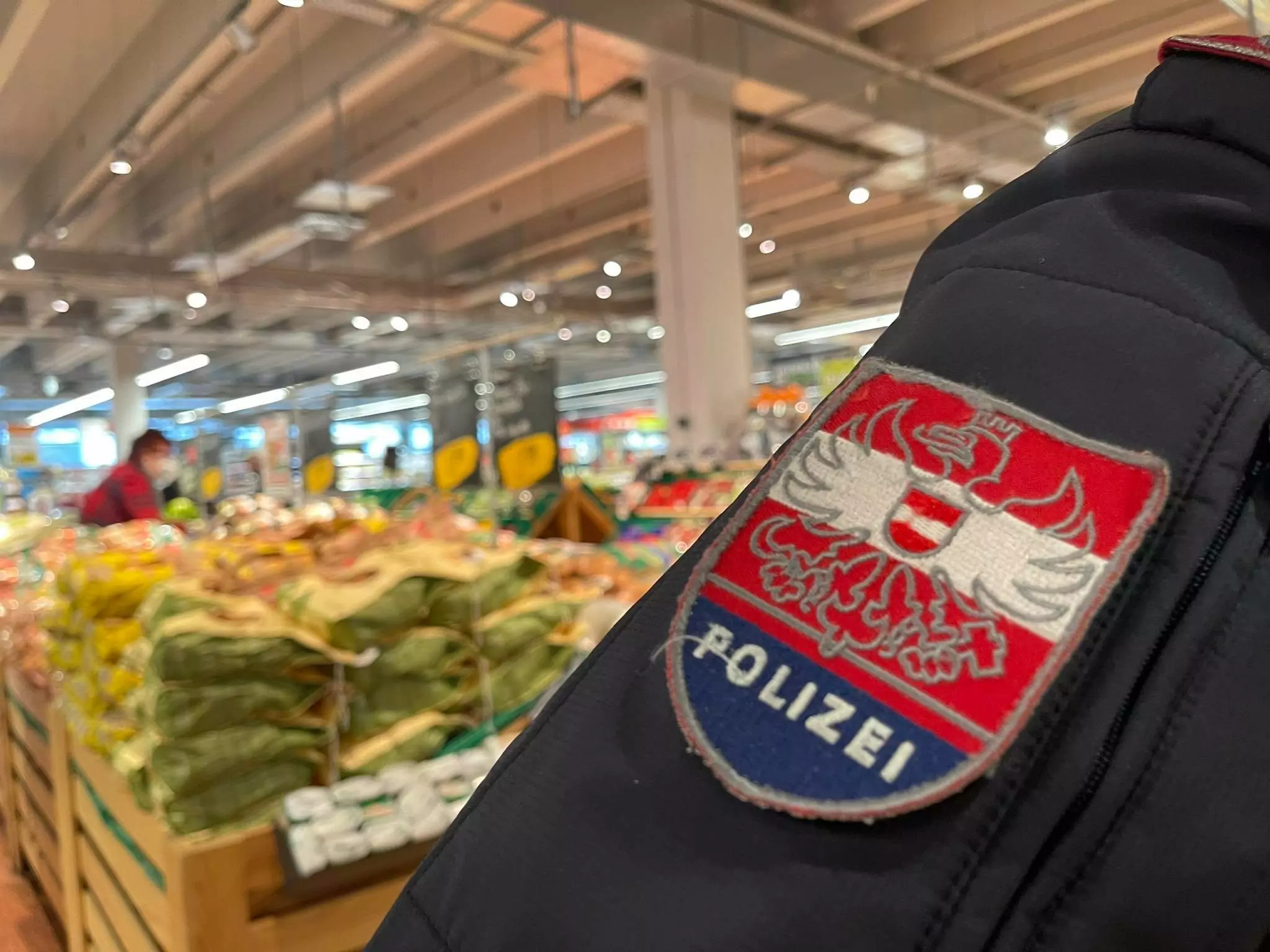 Symbolfoto zu einem Beitrag von 5min.at: Ein Polizist bei einer Kontrolle in einem Supermarkt