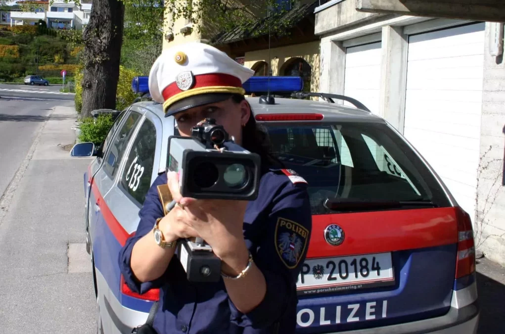 Symbolfoto zu einem Beitrag von 5min.at: Eine Polizistin misst die Geschwindigkeit