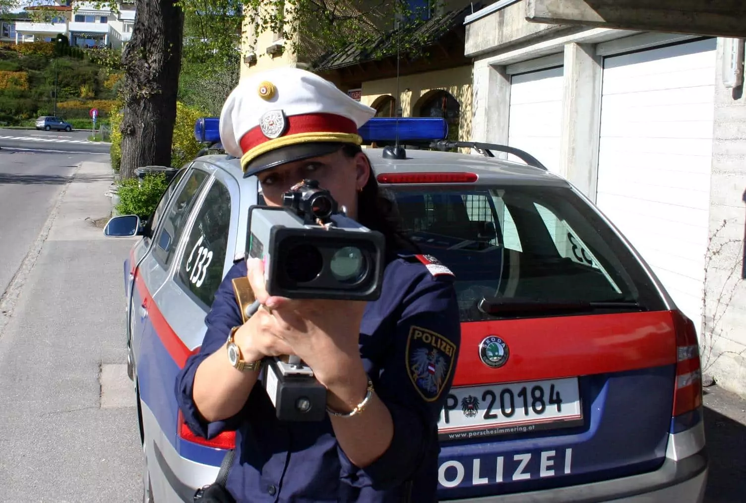 Symbolfoto zu einem Beitrag von 5min.at: Eine Polizistin misst die Geschwindigkeit