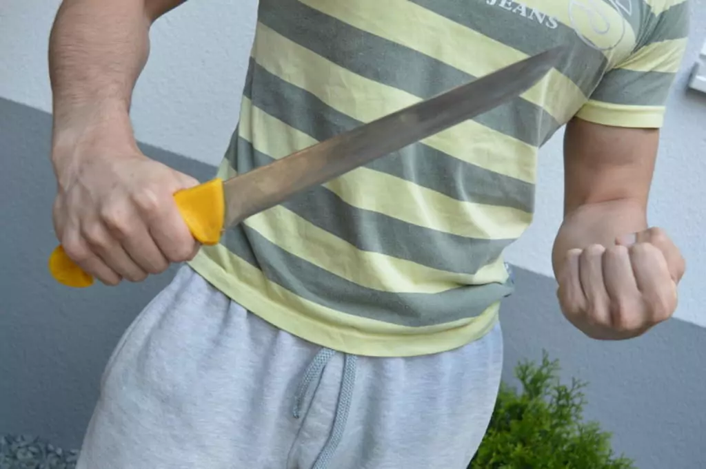Symbolfoto von 5min.at: Mann bedroht sein Opfer mit einem Küchenmesser und einer Faust.