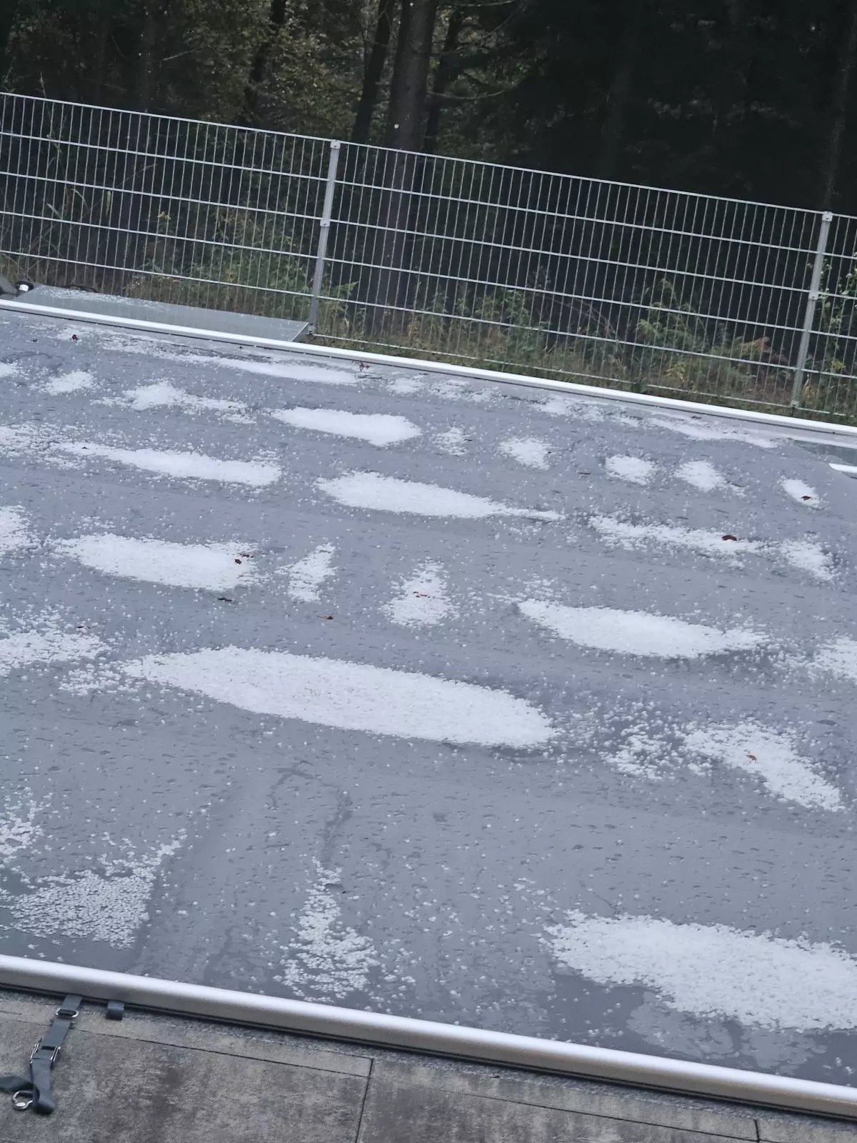 Bild auf 5min.at zeigt mehrere Haufen Hagelkörner auf dem Boden.