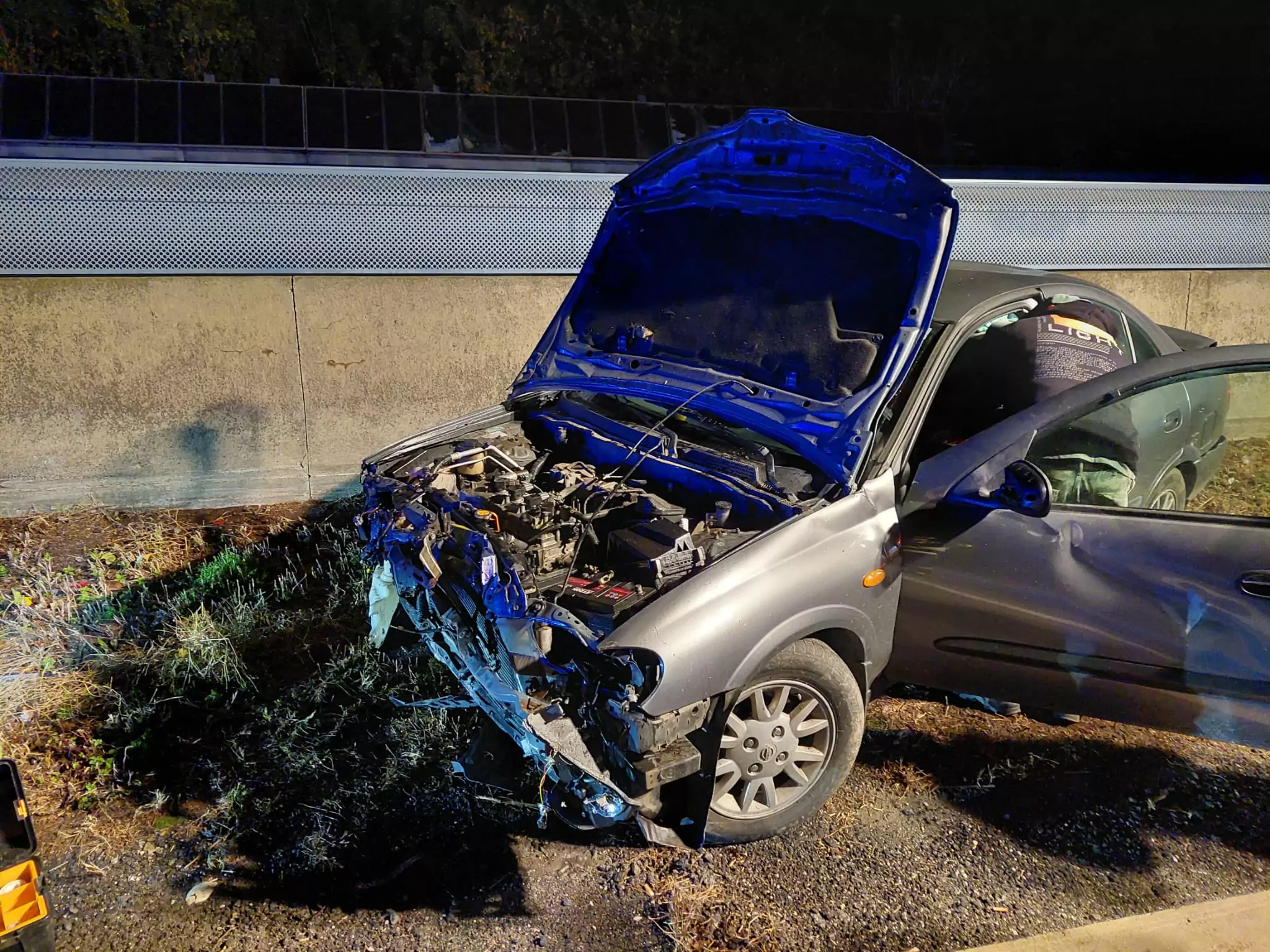 Foto in Beitrag von 5min.at: Zu sehen ist ein verunfalltes Auto auf der A2 Süd Autobahn. Die Motorhaube ist vom Unfall hochgerissen, der Motorblock sieht sehr zerstört aus.