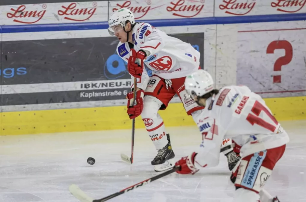 Ein Bild auf 5min.at zeigt zwei Eishockeyspieler des KAC, die einem Puck hinterherjagen.