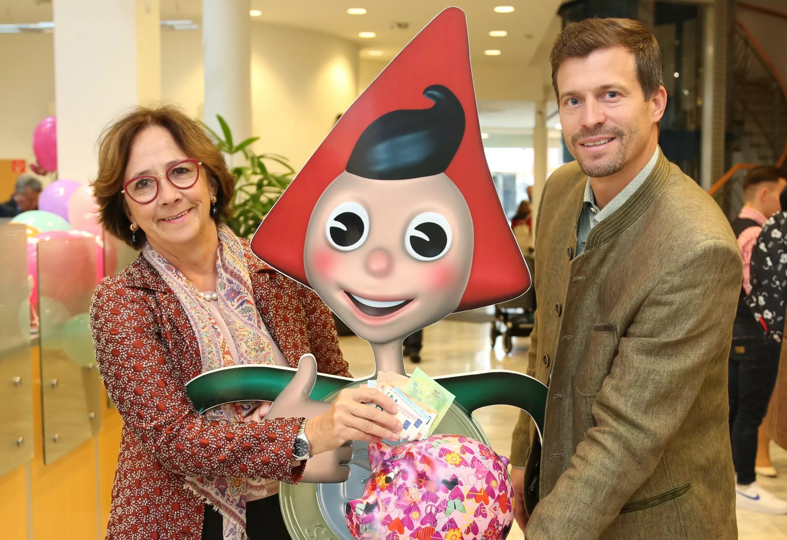 Ein Bild auf 5min.at zeigt Sparkasse Vorstandssprecherin Gabriele Semmelrock-Werzer und Teamleiter Thomas Waldhauser mit dem Sparefroh und einem Sparschwein.