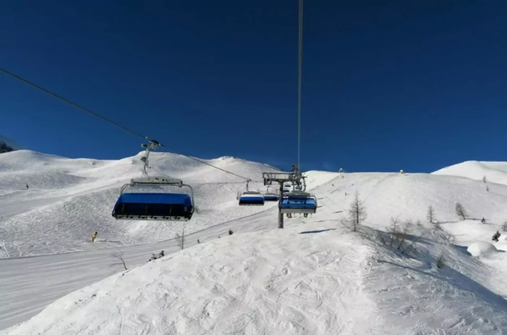 Ein Bild auf 5min.at zeigt einen Sessellift am Nassfeld, darunter eine verschneite Skipiste.
