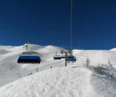 Ein Bild auf 5min.at zeigt einen Sessellift am Nassfeld, darunter eine verschneite Skipiste.