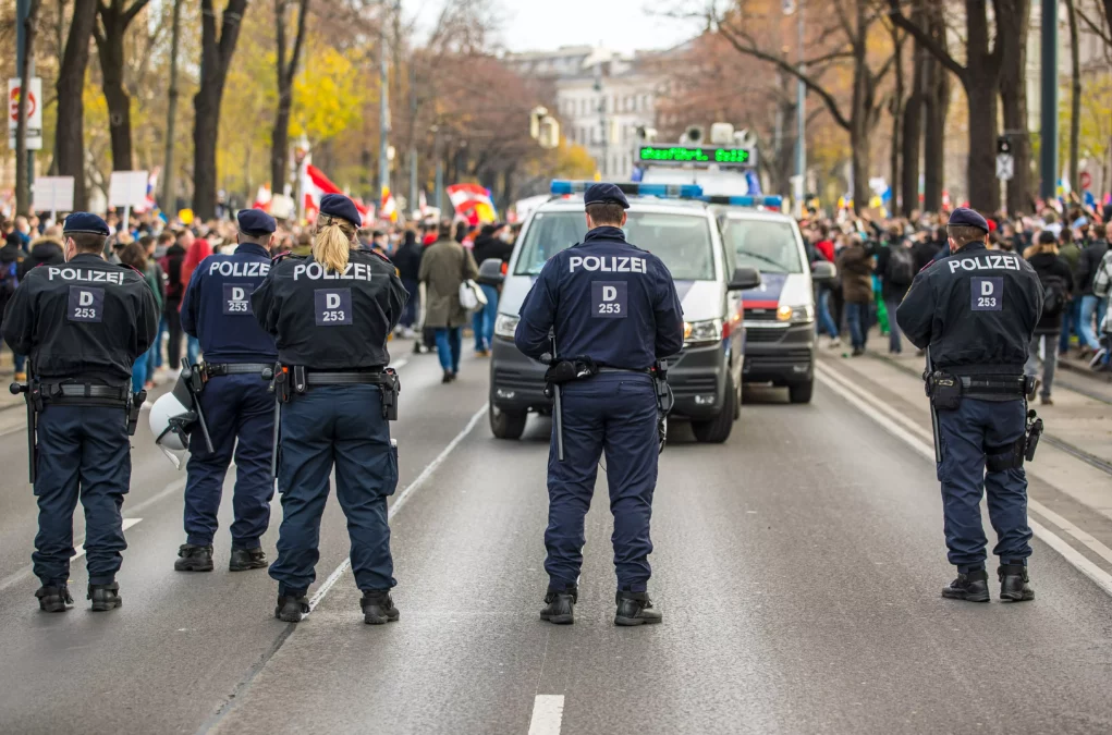 Ein Foto auf 5min.at zeigt Polizisten bei einer Demonstration.