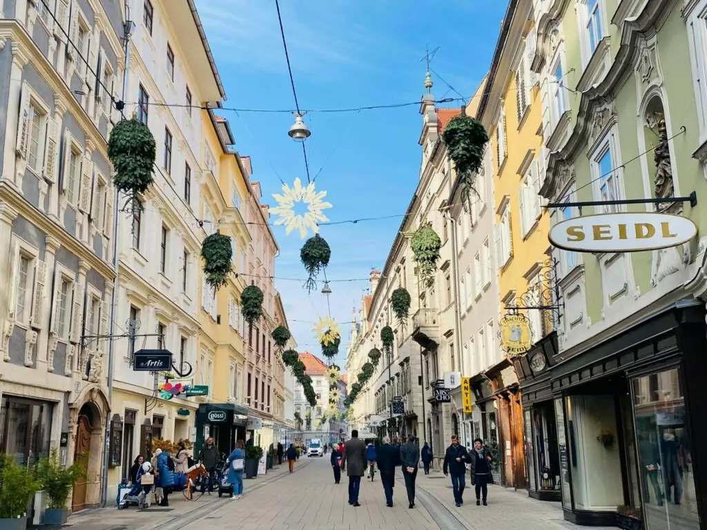 Bild auf 5min.at zeigt die Grazer Schmiedgasse zur Weihnachtszeit mit hängenden Bäumen.