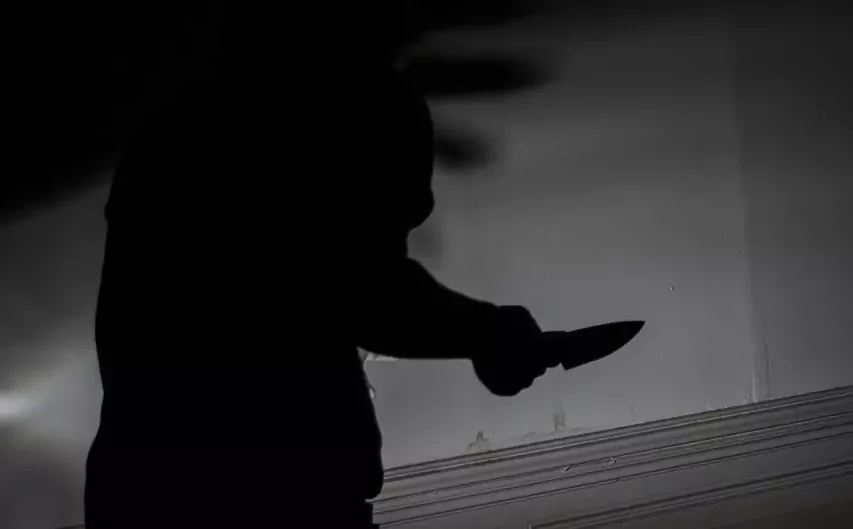 Das Bild auf 5min.at zeigt den Schatten eines mit einem Messer bewaffneten Mannes.
