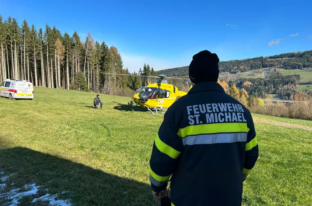 Foto in Beitrag von 5min.at: Zu sehen ist ein Feuerwehrler, der in Richtung des Rettungshubschraubers schaut.