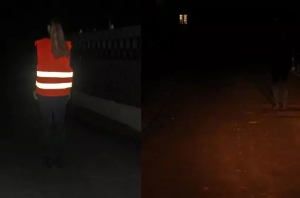 Das Bild auf 5min.at zeigt eine Fußgängerin die mit einer Warnweste bekleidet in der Dunkelheit spazieren geht.
