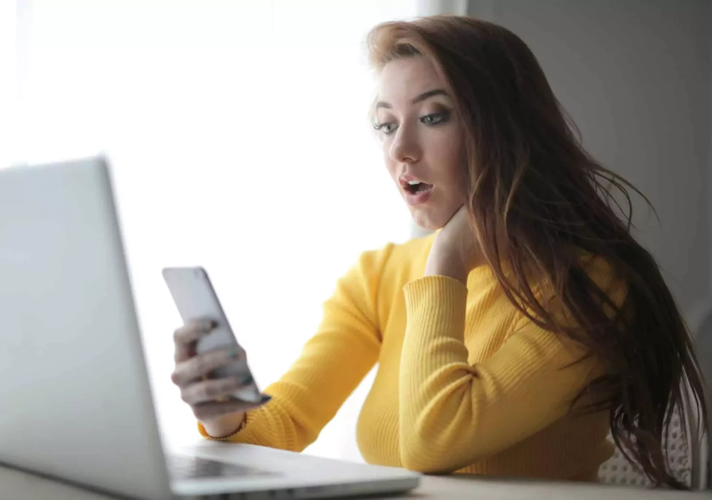 Foto auf 5min.at zeigt eine schockierte Frau, welche auf ihr Handy sieht.