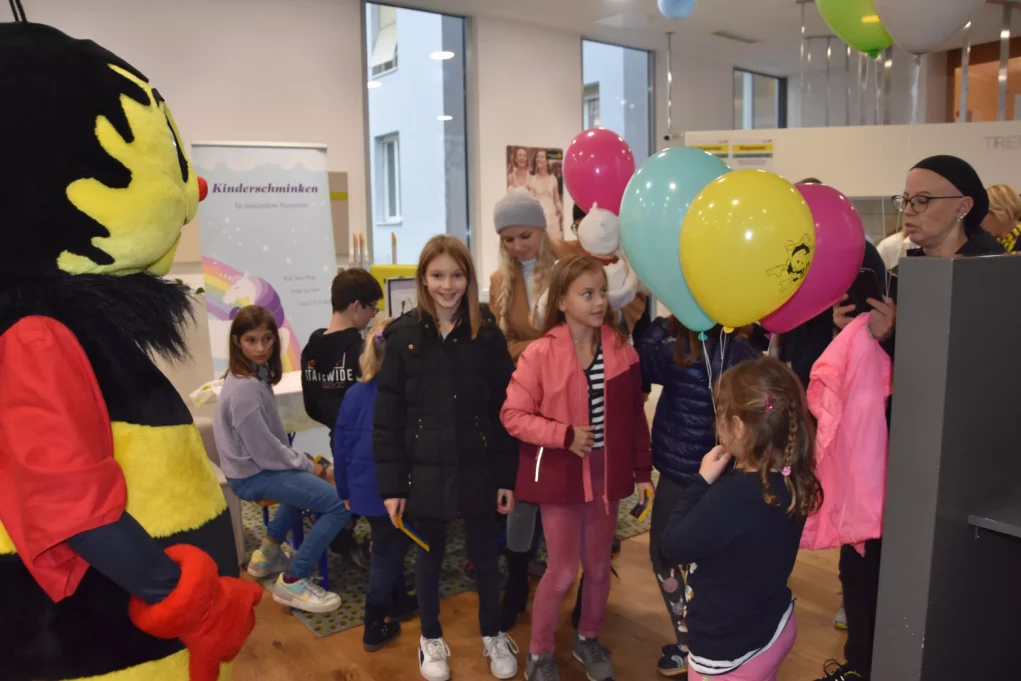 Ein Bild auf 5min.at zeigt, wie ein Sumsi-Maskottchen die Kinder auf der Veranstaltung der Raiffeisenbank Eberndorf besucht.