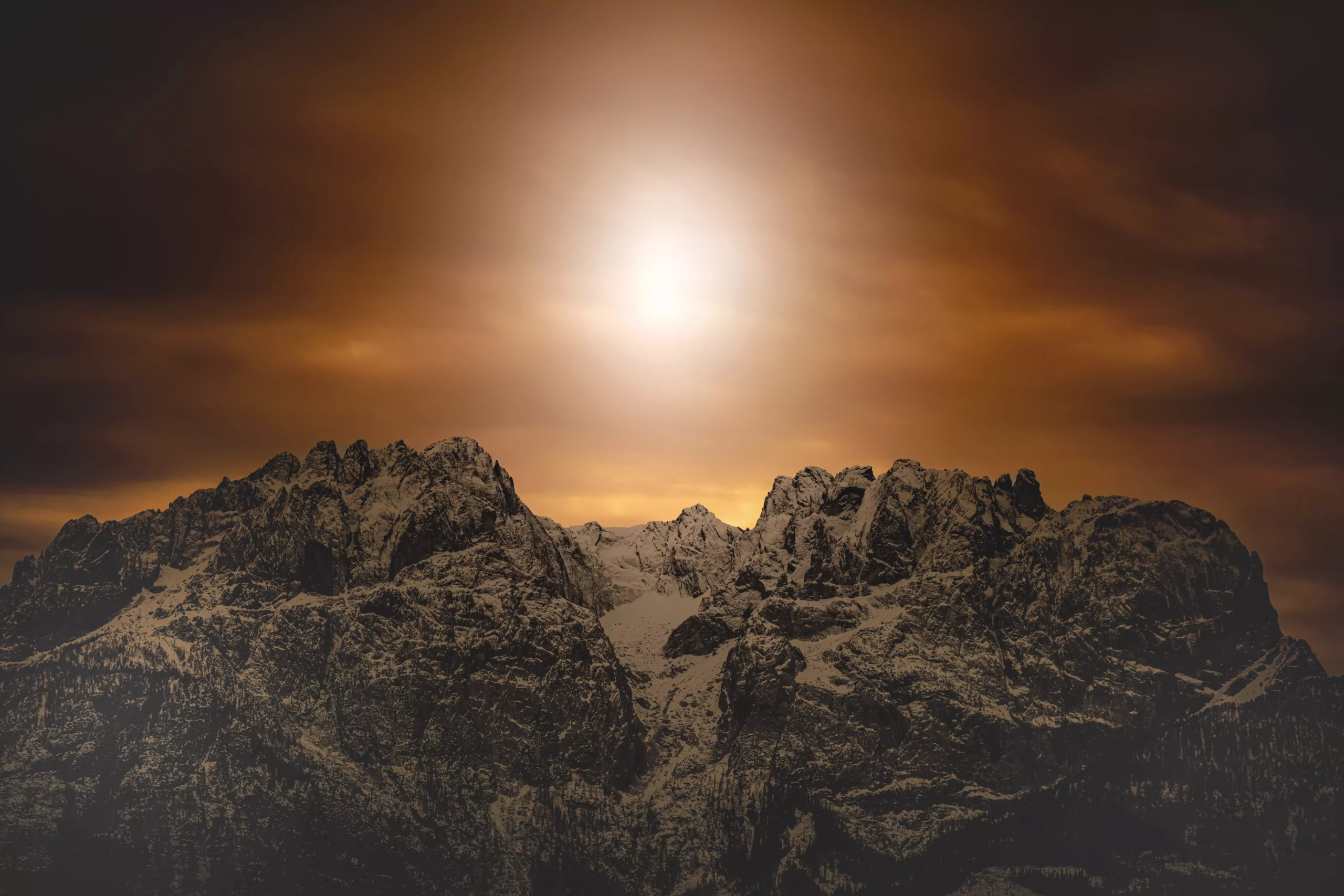 Ein Bild auf 5min.at zeigt die verschneiten Lienzer Dolomiten, dahinter geht gerade die Sonne unter.