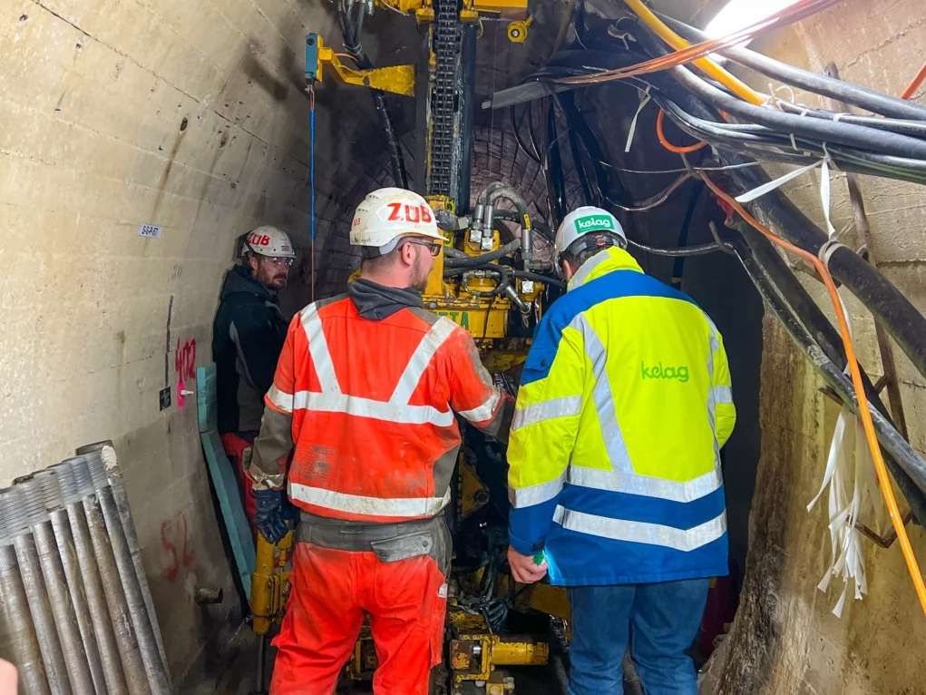 Foto auf 5min.at zeigt Arbeiter in einem Tunnelsystem unter einem Wasserdamm.