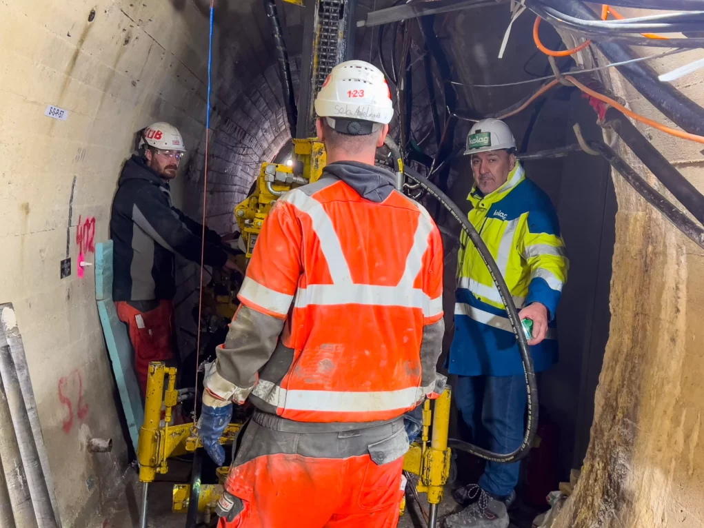 Foto auf 5min.at zeigt Arbeiter in einem Tunnelsystem unter einem Wasserdamm.