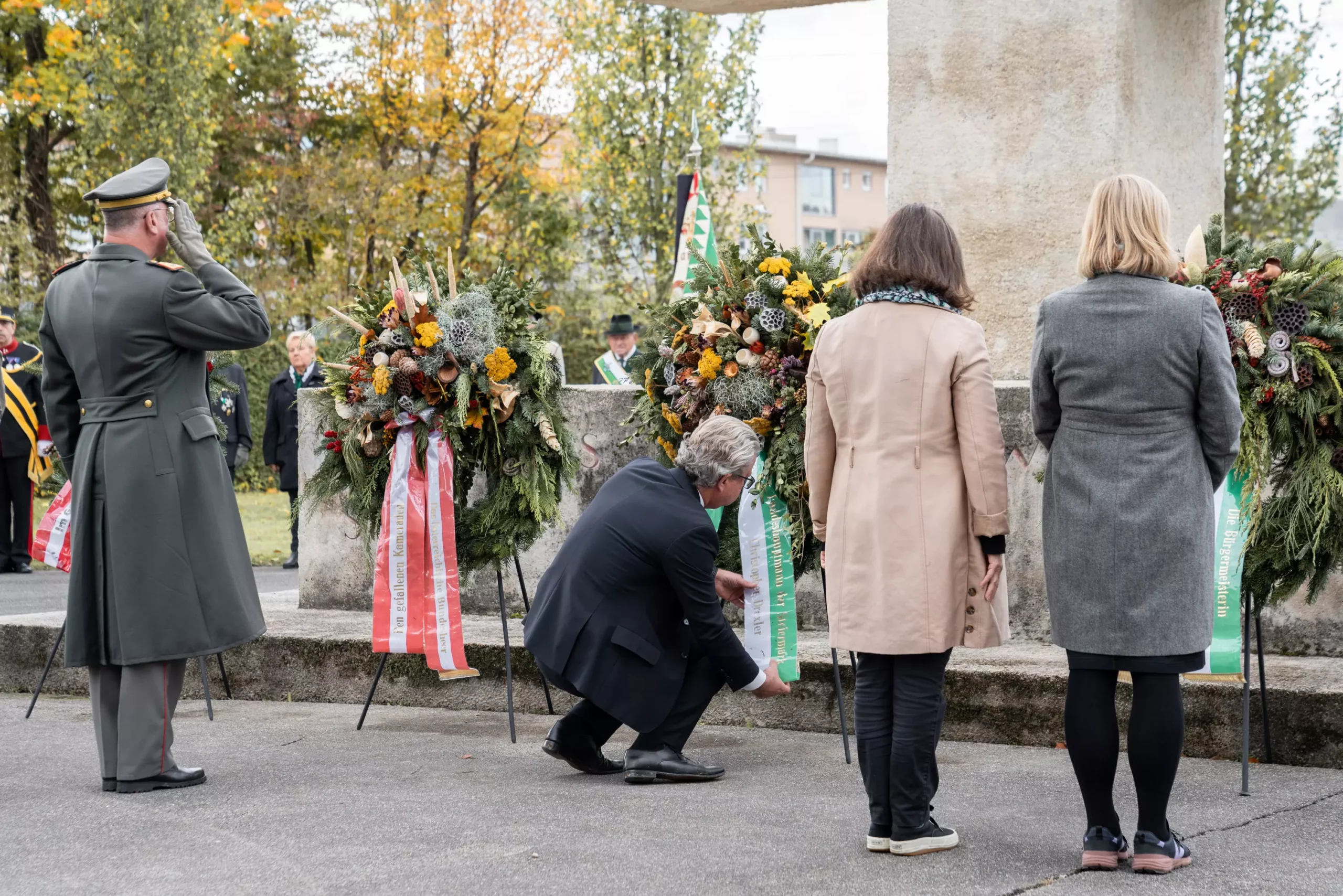 Bild auf 5min.at zeigt mehrere Personen bei der Kranzniederlegung am Zentralfriedhof in Graz.