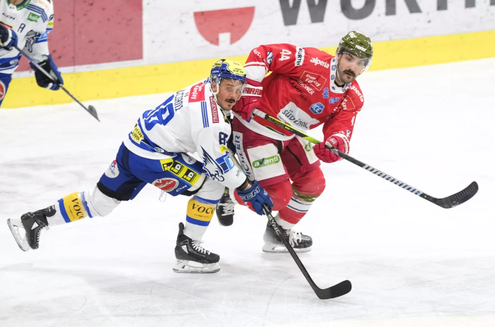 Foto in Beitrag von 5min.at: Zu sehen sind zwei Eishockeyspieler mit den Schlägern in der Hand, die dem Puck nachjagen.