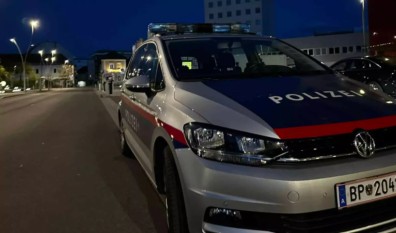 Ein Bild auf 5min.at zeigt einen parkenden Streifenwagen der Polizei bei Nacht.