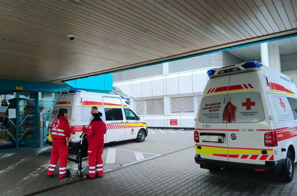 Ein Bild auf 5min.at zeigt den Haupteingang des Landeskrankenhauses Villach. Davor stehen Rettungskräfte. Ein Rettungswagen parkt auf der rechten Seite.