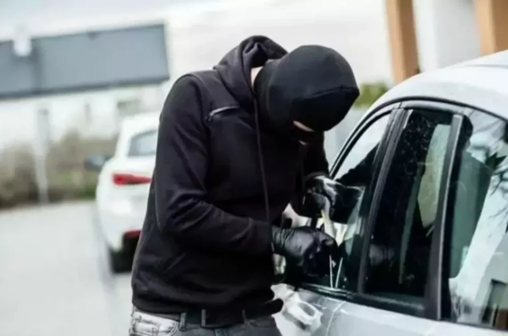 Foto in Beitrag von 5min.at: Zu sehen ist ein Dieb, der in ein Auto einbrechen versucht.