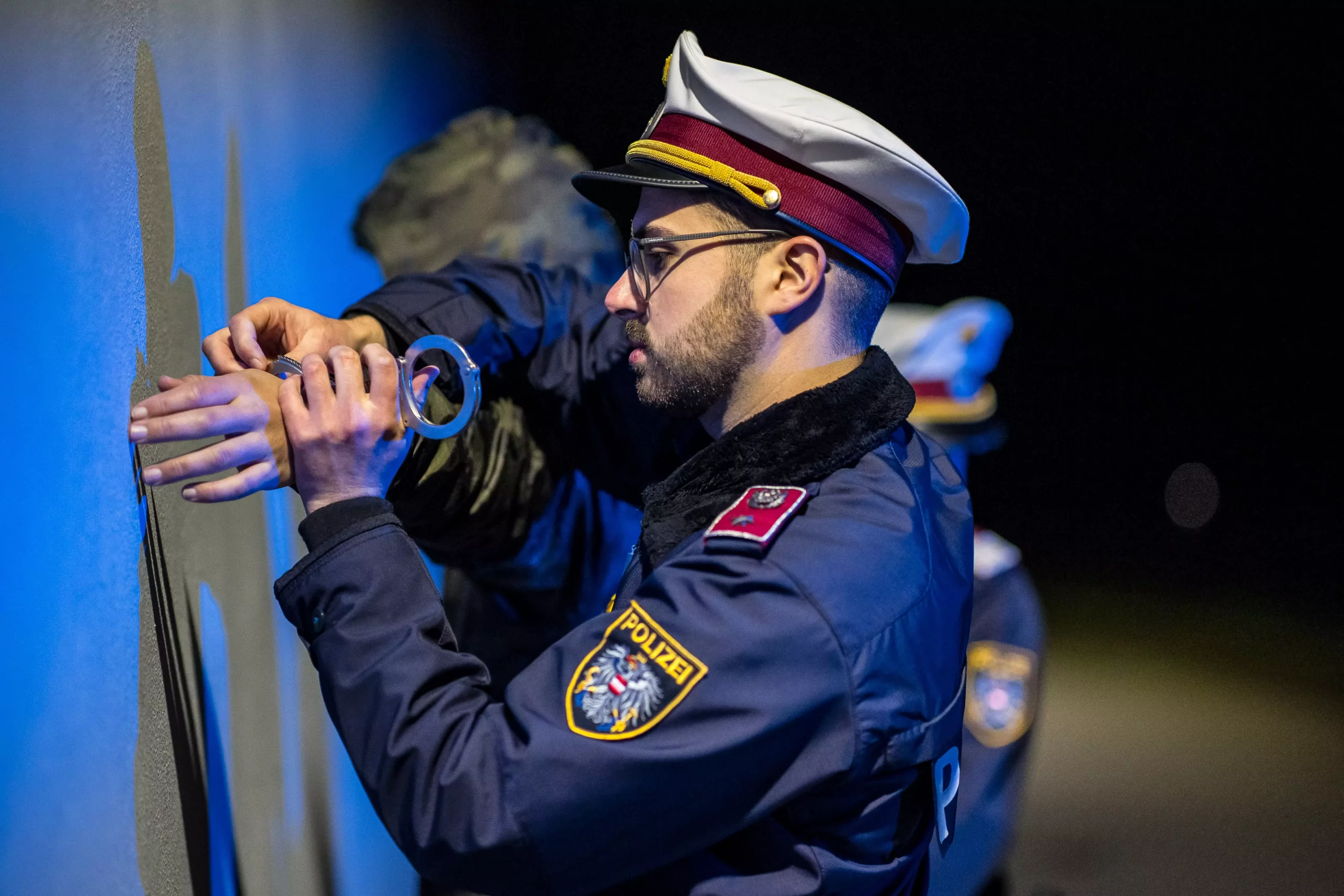 Foto in Beitrag von 5min.at: Zu sehen sind zwei Polizisten, die einen Mann festnehmen.