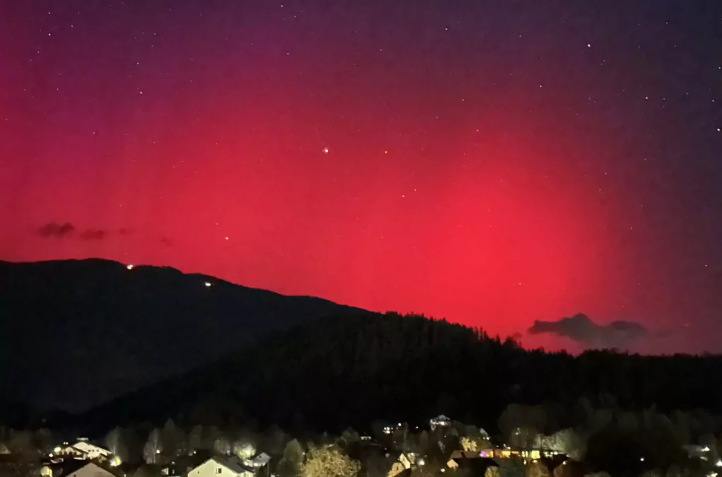 Ein Bild auf 5min.at zeigt pinkfarbene Polarlichter, die am Nachthimmel leuchten.