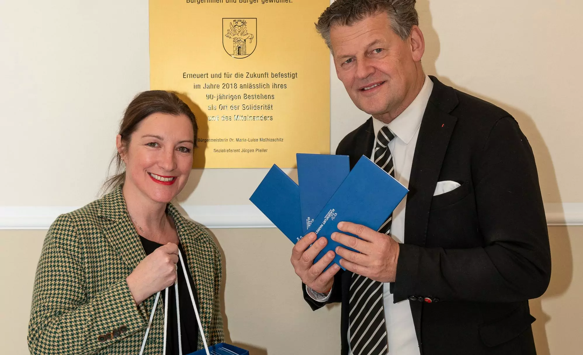 Ein Bild auf 5min.at zeigt Bürgermeister Christian Scheider und Abteilungsleiter-Stellvertreterin Nadja Reiter in der Klagenfurter Volksküche. Der Bürgermeister hält die Gutscheine in der Hand.