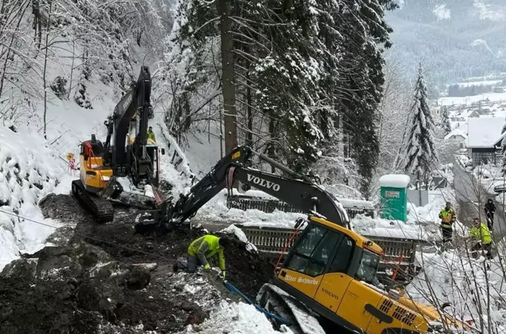 Bild auf 5min.at zeigt die Feuerwehr bei einem Einsatz. Ein Bagger drohte im Schnee abzustürzen.