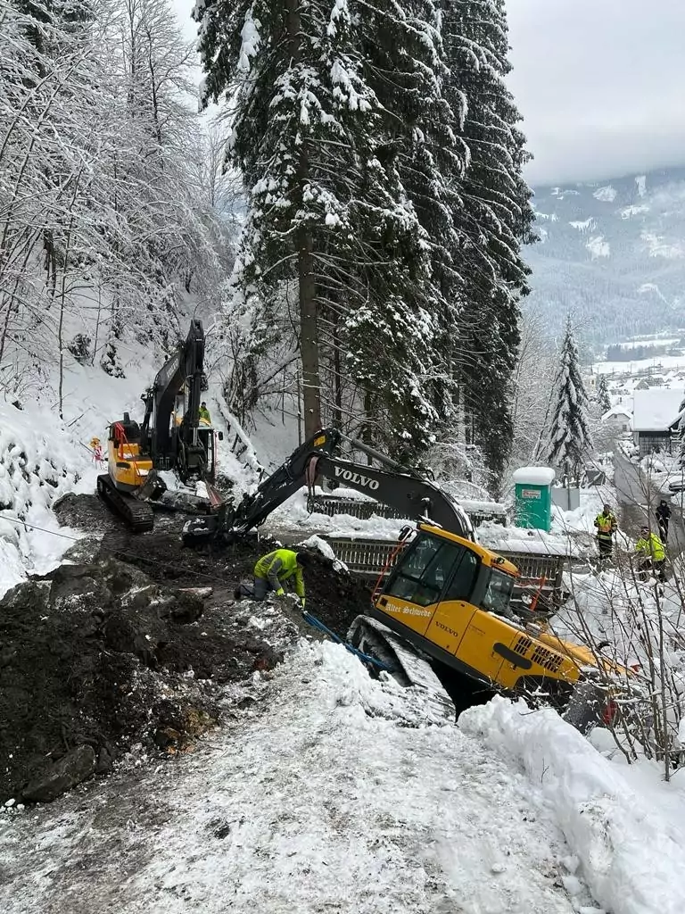 Bild auf 5min.at zeigt die Feuerwehr bei einem Einsatz. Ein Bagger drohte im Schnee abzustürzen.