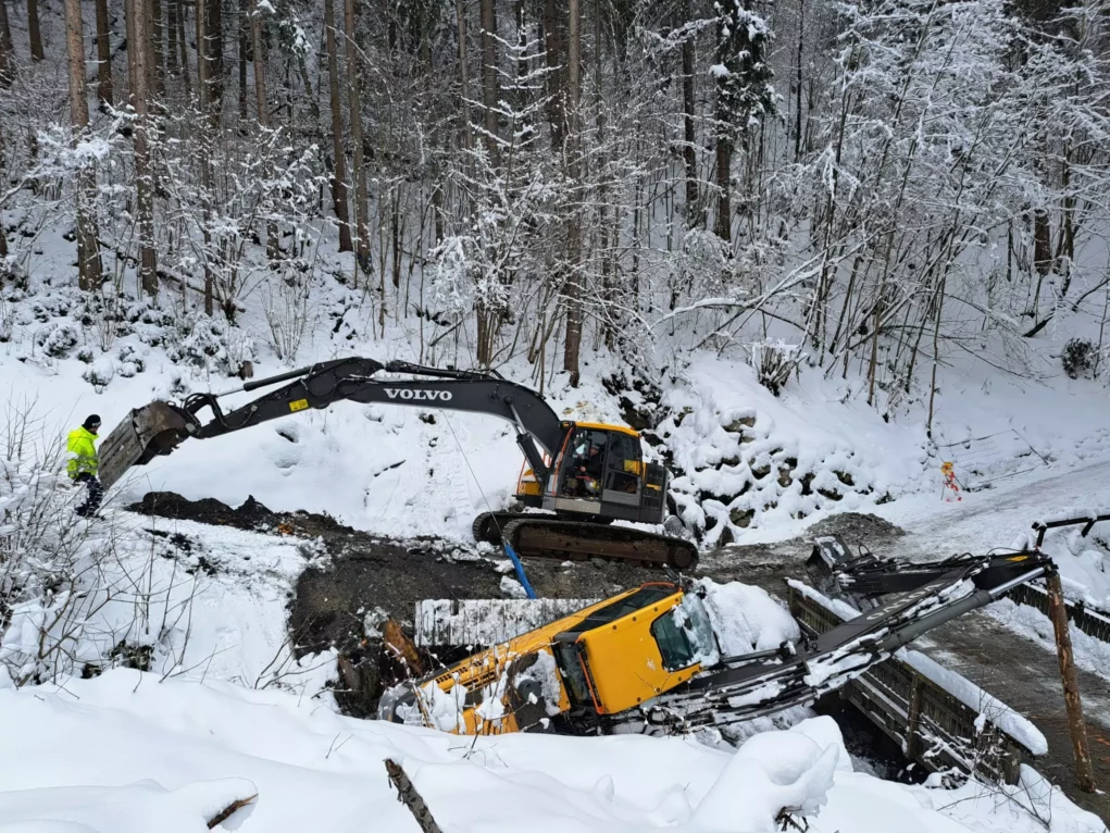 Bild auf 5min.at zeigt die Feuerwehr bei einem Einsatz. Ein Bagger drohte im Schnee abzustürzen.