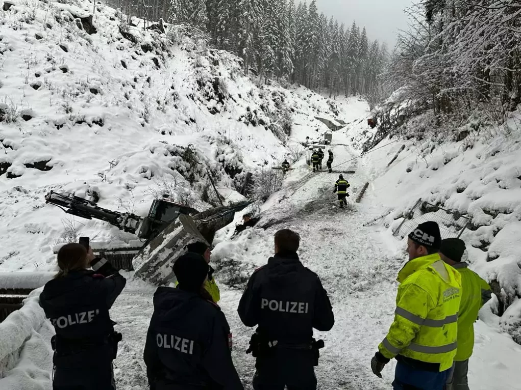 Bild auf 5min.at zeigt die Feuerwehr bei einem Einsatz. Ein Bagger drohte im Schnee abzustürzen.