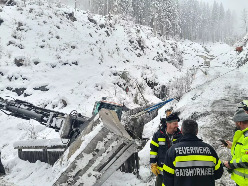 Bild auf 5min.at zeigt die Feuerwehr bei einem Einsatz. Ein Bagger drohte im Schnee abzustürzen.