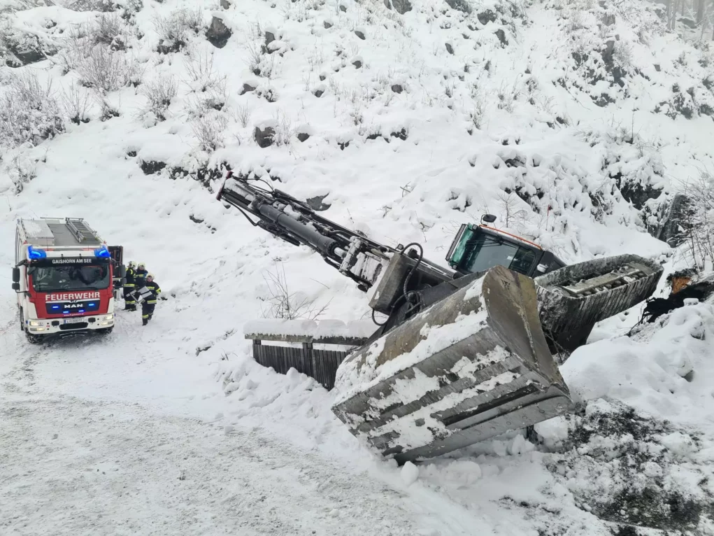 Bild auf 5min.at zeigt die Feuerwehr bei einem Einsatz. Ein Bagger drohte im Schnee abzustürzen.