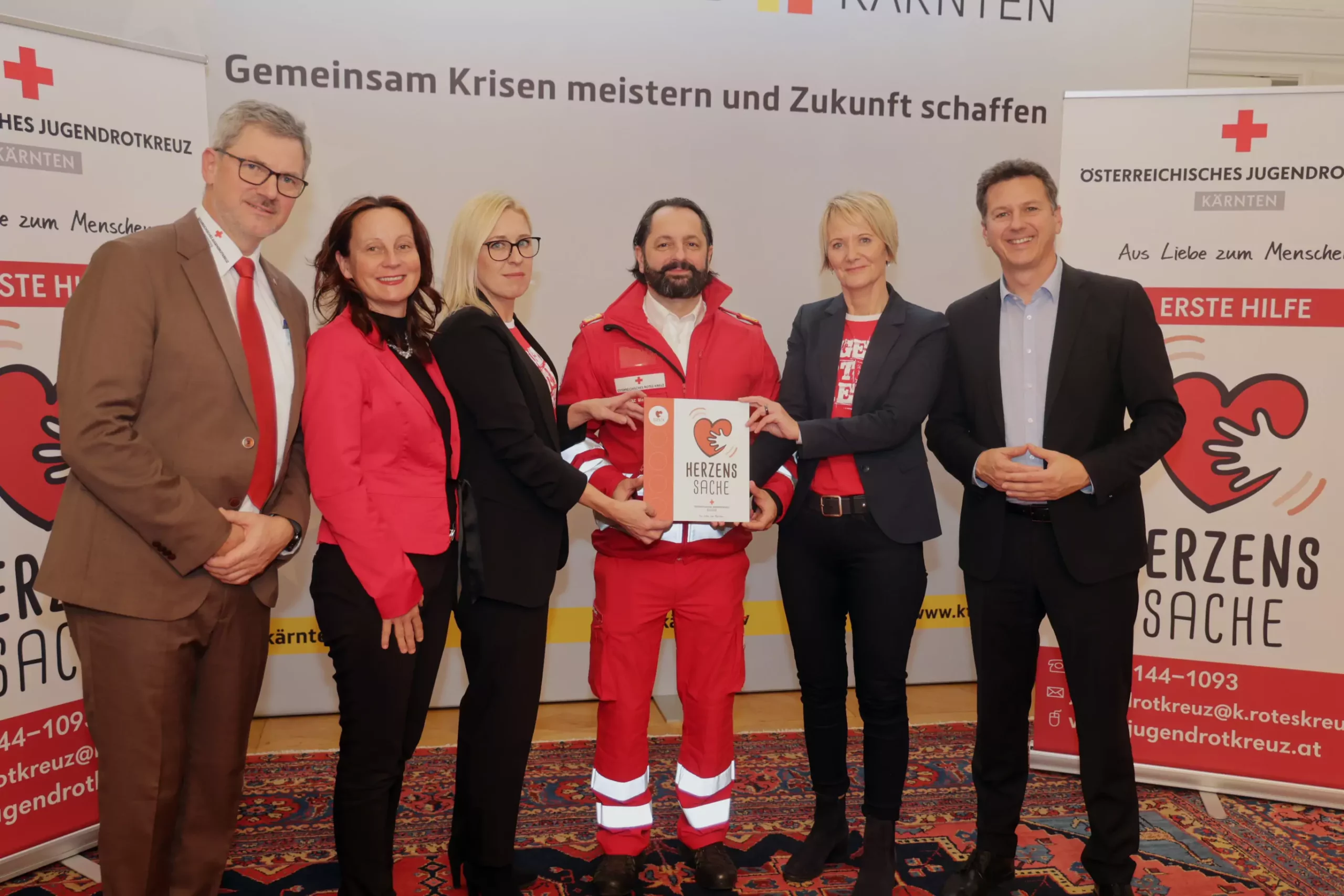 Bild auf 5min.at zeigt ein Gruppenbild mit Mitarbeiter des Roten Kreuzes im Kärntner Spiegelsaal.