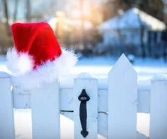 Foto in Beitrag von 5min.at: Zu sehen ist eine Weihnachtsm&uuml;tze auf einem wei&szlig;en Zaun. Dahinter liegt Schnee.